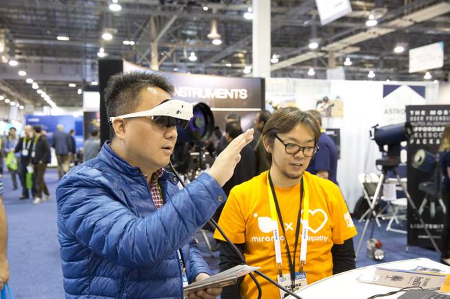 A showgoers tests out augmented reality glasses by Mirama, where data and other information is overlaid on  the users field of view, CES Wed. Jan 6, 2016.
