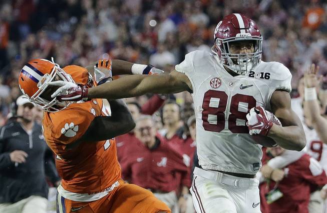 Alabama's O.J. Howard tries to get past Clemson's T.J. Green after a catch during the second half of the NCAA college football playoff championship game Monday, Jan. 11, 2016, in Glendale, Ariz. 