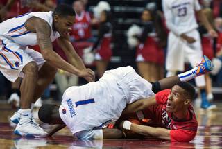 Boise State guard Mikey Thompson (1) rolls over UNLV guard Patrick McCaw (22) fighting for a loose ball during their game at the Thomas & Mack Center on Wednesday, January 27, 2016.