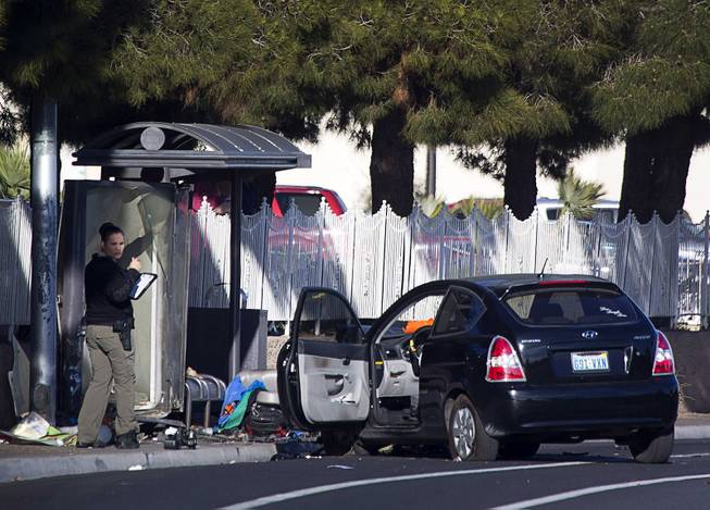 A Metro Police crime scene analyst looks over the scene of auto-pedestrian accident at a bus shelter on Lake Mead Boulevard near Rancho Drive Thursday, Feb. 4, 2016.