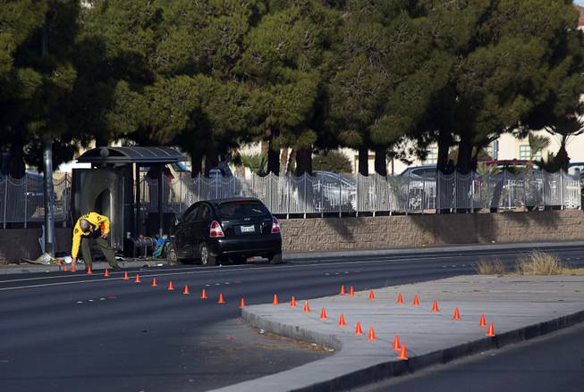 A Metro Police accident investigator places evidence cones at the scene of auto-pedestrian accident at a bus shelter on Lake Mead Boulevard near Rancho Drive Thursday, Feb. 4, 2016.