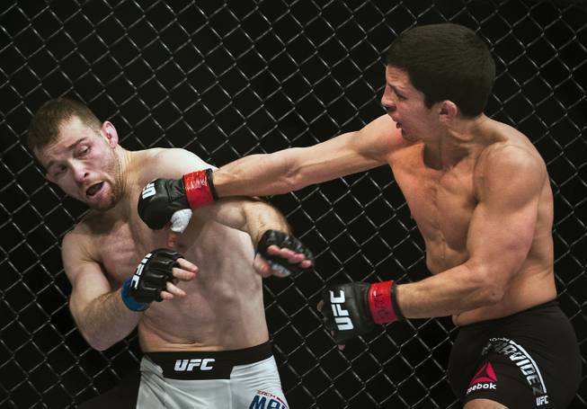 Flyweight Zach Makovsky takes a punch from Joseph Benavidez during their UFC Fight Night 82 match at the MGM Grand Garden Arena 