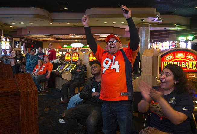 Denver Broncos fan Guillermo Dominguez of Denver celebrates as he watches Super Bowl 50 on Sunday, Feb. 7, 2016, in the Westgate Super Book. His daughter, Amanda Dominguez, applauds at right.