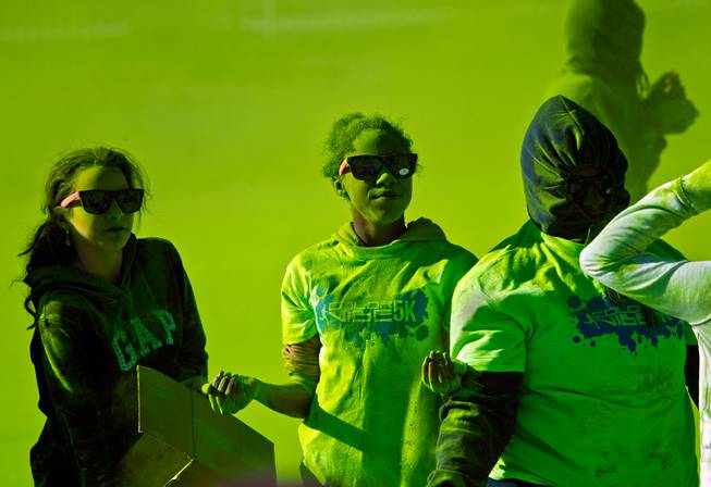 Volunteers are covered with green dust as they toss it on runners at a checkpoint during the Las Vegas Color Vibe 5K run at Craig Ranch Park on Saturday, February 6 2016.  A portion of the proceeds from the event will benefit the Nevada Childhood Cancer Foundation.  L.E. Baskow
