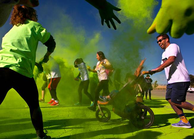 Runners are tossed with green dust as they move past a checkpoint during the Las Vegas Color Vibe 5K run at Craig Ranch Park on Saturday, February 6 2016.  A portion of the proceeds from the event will benefit the Nevada Childhood Cancer Foundation.  L.E. Baskow