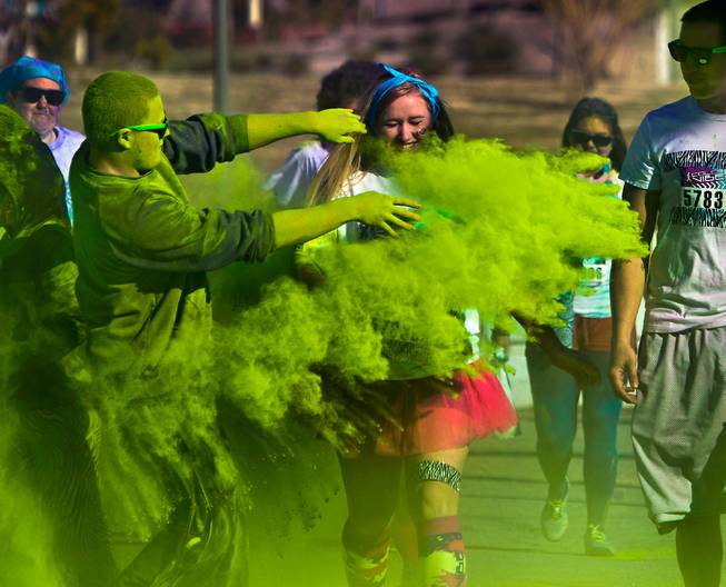 Runners are tossed with green dust as they move past a checkpoint during the Las Vegas Color Vibe 5K run at Craig Ranch Park on Saturday, February 6 2016.  A portion of the proceeds from the event will benefit the Nevada Childhood Cancer Foundation.  L.E. Baskow