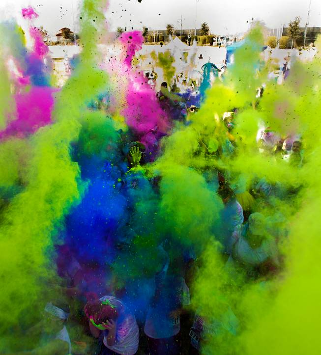 Runners toss colored dust in the air about the stage following the Las Vegas Color Vibe 5K run at Craig Ranch Park on Saturday, February 6 2016.  A portion of the proceeds from the event will benefit the Nevada Childhood Cancer Foundation.  L.E. Baskow