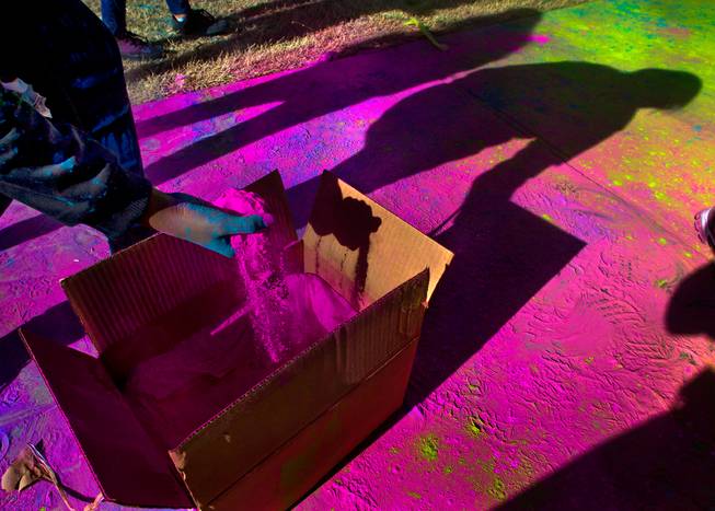 A volunteer scoops out more dust to toss on runners during the Las Vegas Color Vibe 5K run at Craig Ranch Park on Saturday, February 6 2016.  A portion of the proceeds from the event will benefit the Nevada Childhood Cancer Foundation.  L.E. Baskow