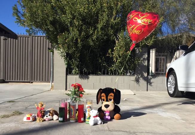 Candles, a balloon and stuff animals are among items left Monday, Feb. 8, 2016, in memory of 2-year-old Evelyn Green, who was hit by a van and killed the previous evening in the 3400 block of Thomas Avenue in North Las Vegas.