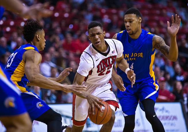 UNLV guard Patrick McCaw (22) splits the double team of San Jose State guard Princeton Onwas (23) and  San Jose State forward Frank Rogers (14) at the Thomas & Mack Center on Wednesday, February 10, 2016.