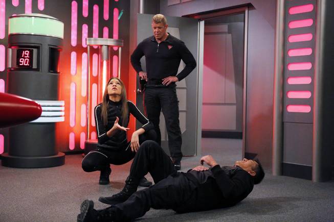 This image shows Zendaya, left, as K.C. Cooper and Lee Reherman, standing, as Victor in “K.C. Undercover” on the Disney Channel. Reherman, the former Ivy League football star who shot to fame as the towering, muscular Hawk on “American Gladiators,” died Tuesday, March 1, 2016, at age 49. 