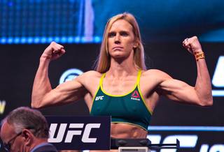 UFC Women's Bantamweight Champion Holly Holm flexes on the scale during the UFC 196 weigh ins at the MGM Grand Garden Arena on Friday, March 4, 2016.