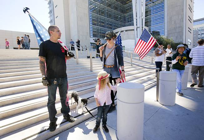 Brian and Leslie Enright of Palm Desert, Calif., supporters of Nevada rancher Cliven Bundy, picket with their daughter Maryanne, 4 and dog Mia in front of the U.S. Courthouse in downtown Las Vegas Thursday, March 10, 2016. Bundy is facing charges relating to an armed ranching standoff against Bureau of Land Management agents in April 2014.