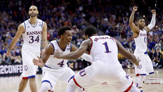 Kansas players celebrate after winning an NCAA college basketball game against West Virginia in the finals of the Big 12 conference tournament Saturday, March 12, 2016, in Kansas City, Mo.