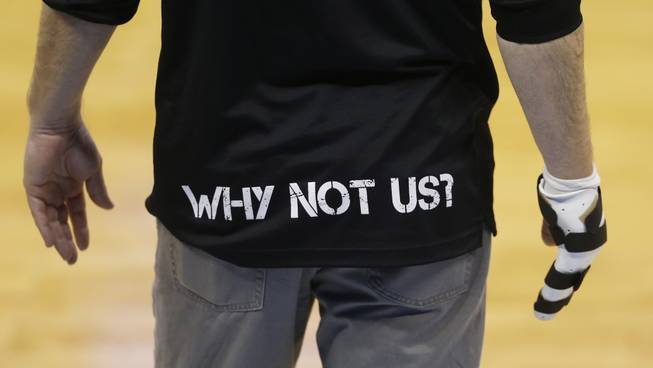 Arkansas-Little Rock head coach Chris Beard wears a shirt with message on his back as he holds out his injured right hand during practice for a first-round men's college basketball game in the NCAA Tournament, March 16, 2016, in the NCAA Tournament in Denver. Arkansas-Little Rock faces Purdue on Thursday.