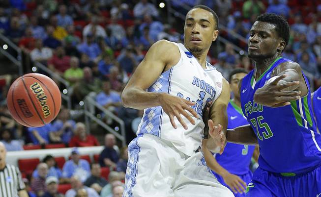 Florida Gulf Coast forward Marc Eddy Norelia (25) moves the ball off North Carolina forward Brice Johnson (11) during the second half of a first-round men's college basketball game in the NCAA Tournament, Thursday, March 17, 2016, in Raleigh, N.C. 