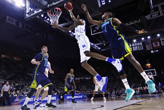 Duke guard Brandon Ingram, center, drives to the basket past North Carolina-Wilmington guard Chris Flemmings (1) during the first half in the first round of the NCAA men’s basketball tournament Thursday, March 17, 2016, in Providence, R.I.
