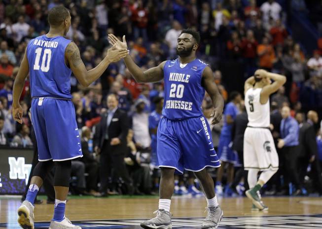 Middle Tennessee's Jaqawn Raymond, left, celebrates with teammate Giddy Potts as Michigan State's Bryn Forbes walks away.