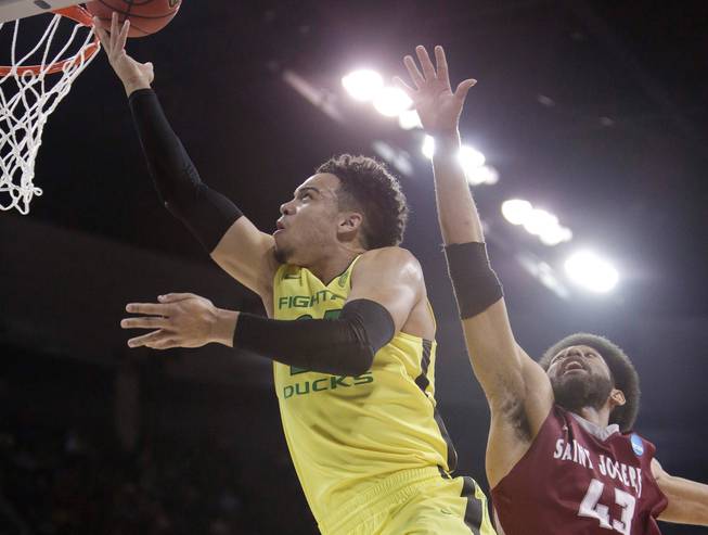 Oregon forward Dillon Brooks, left, shoots against Saint Joseph's forward DeAndre Bembry on Sunday, March 20, 2016, during the first half of a second-round men's college basketball game in the NCAA Tournament in Spokane, Wash.