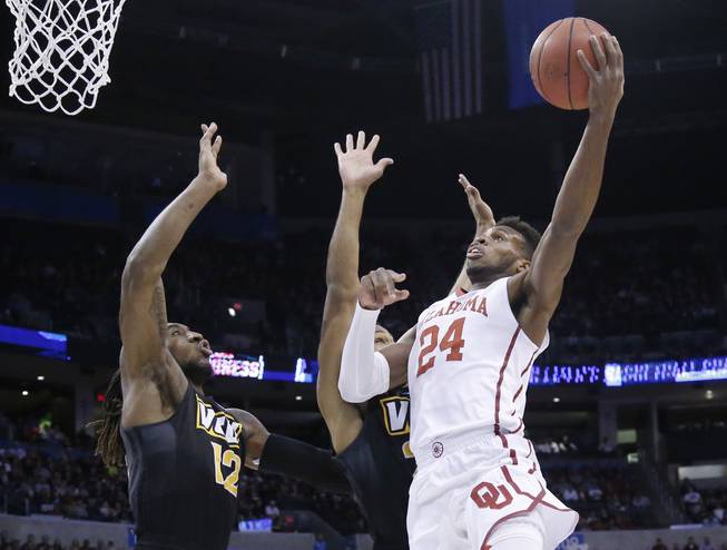 Oklahoma guard Buddy Hield, right, shoots over Virginia Commonwealth forward Mo Alie-Cox, left, and guard Jordan Burgess in the first half of a second-round men's college basketball game Sunday, March 20, 2016, in the NCAA Tournament in Oklahoma City.
