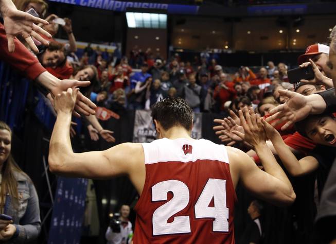 Wisconsin's Bronson Koenig is congratulated by fans as he leaves the court after hitting a three-point basket at the buzzer to defeat Xavier in a second-round men's college basketball game in the NCAA Tournament, Sunday, March 20, 2016, in St. Louis. Wisconsin won 66-63.