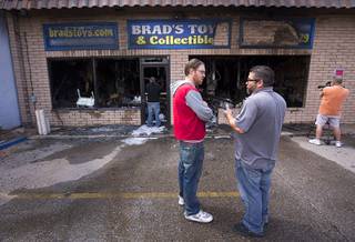 Brad Howard, center, owner of Brad's Toys & Collectibles, talks with Kert Dabash, of Majestic Restoration Services, after an early morning fire destroyed his shop at 1433 N. Boulder Highway in Henderson Wednesday, March 30, 2016. Howard said he is not insured for the loss but is establishing a Go Fund Me account to try and raise money to rebuild the shop.