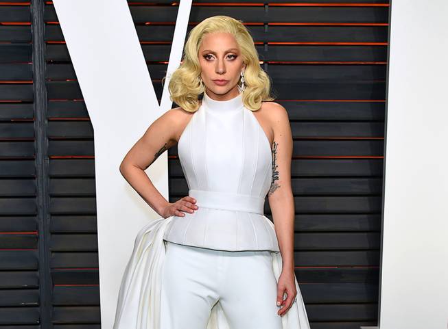 In this Feb. 28, 2016, photo, Lady Gaga arrives at the Vanity Fair Oscar Party in Beverly Hills, Calif. Lady Gaga and Vice President Joe Biden take the stage in Las Vegas for an event raising awareness about sexual assault on college campuses. The pop star and the vice president will hold a rally at UNLV on April 7 as part of the White House’s "It's On Us" campaign. 