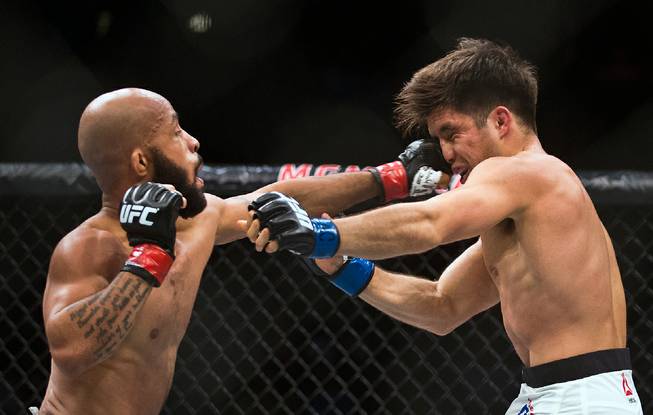 Flyweight Champion Demetrious Johnson drives a punch directly to the face of Henry Cejudo during their UFC 197 match at the MGM Grand Garden Arena on Friday, April 23, 2016.