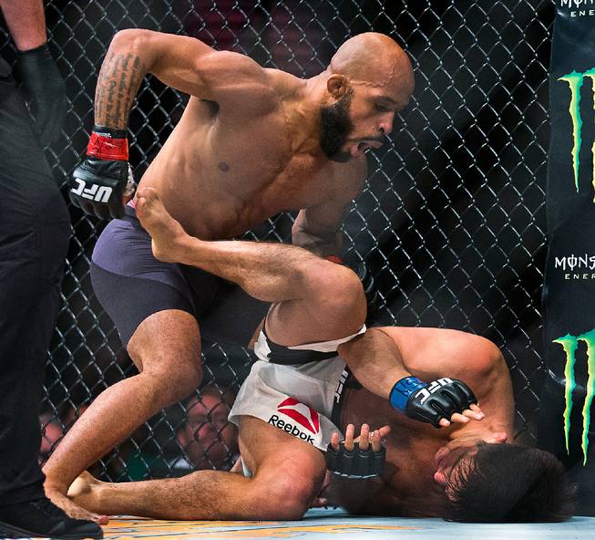 Flyweight Champion Demetrious Johnson finishes off Henry Cejudo down on the canvas from a knockout during their UFC 197 match at the MGM Grand Garden Arena on Friday, April 23, 2016.