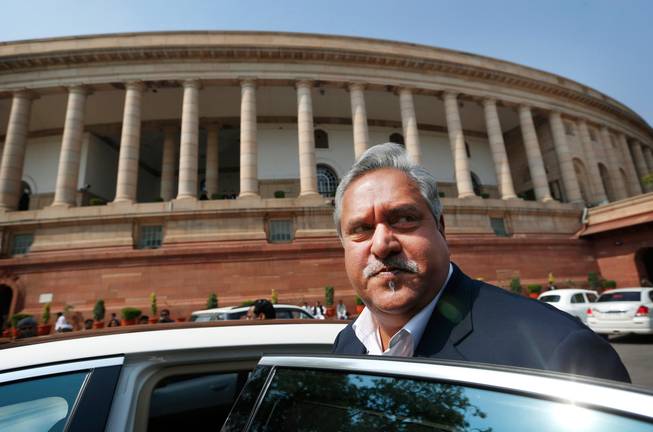 Indian business tycoon and owner of Kingfisher Airlines Vijay Mallya gets into his car outside the Parliament in New Delhi, India, on Feb. 27, 2013. India has revoked the passport of the flamboyant Indian businessman accused of fleeing to London in March while owing more than a billion dollars to Indian banks.