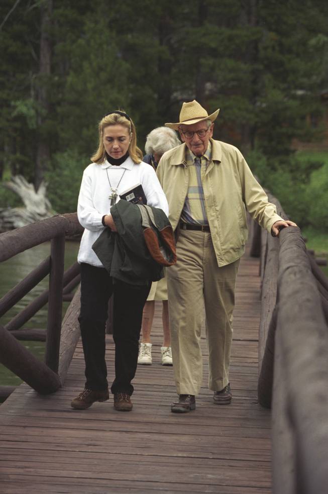 An undated photo from the Clinton Presidential Library shows Hillary Clinton in 1995 carrying a copy of "Are We Alone: Philosophical Implications of the Discovery of Extraterrestrial life" by Paul Davies, with Laurence Rockefeller at the J.Y. Ranch in Jackson Hole, Wyo.