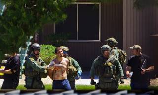 An injured man is escorted away by Metro SWAT members after being barricaded and possibly armed inside a central valley apartment off of W. Sirius Ave on Thursday, May 12, 2016.