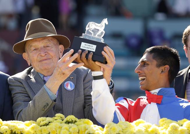 Owner/breeder Fred Bradley, left, holds up a trophy with jockey Rajiv Maragh in the winner's circle after Groupie Doll won the Breeders' Cup Filly & Mare Sprint horse race Nov. 12, 2012, at Santa Anita Park in Arcadia, Calif. Bradley, a former Kentucky lawmaker and longtime thoroughbred breeder whose stable of stakes winners included champion female sprinter Groupie Doll, died Friday, May 20, 2016, in Wilmore, Kentucky, following a long illness, his son William "Buff" Bradley said. He was 85. 