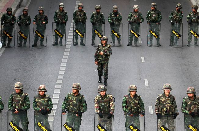 Thai soldiers form a line May 29, 2014, while guarding a bus stop area to prevent an anti-coup demonstration at Victory Monument in Bangkok, Thailand. Thailand’s military seized power from an elected government on May 22, 2014.