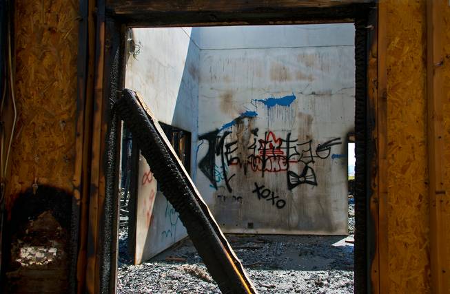 Graffiti remains on a wall within and abandoned home which burned again early this morning at the corner of Raven Avenue and Inspiration Drive on Tuesday, May 24, 2016.