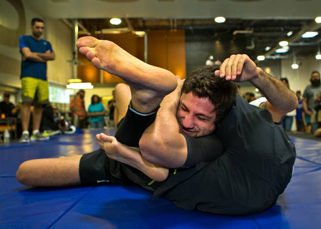 The trainer for Bantamweight Thomas Almeida has his head locked on the mat during the UFC Fight Night workouts at the Las Vegas Harley Davidson store on Thursday, May 27, 2016.