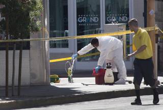 A Logistical Solutions employee cleans a sidewalk at Ogden Avenue and Third Street after an early morning shooting in downtown Las Vegas sent four people to the hospital early Sunday morning, May 29, 2016.