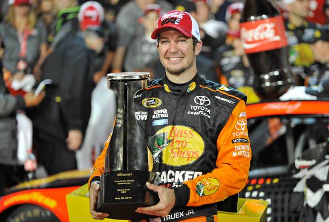 Martin Truex Jr. poses with the trophy Sunday, May 29, 2016, after winning the NASCAR Sprint Cup series auto race at Charlotte Motor Speedway in Concord, N.C.