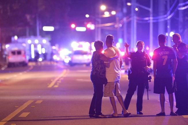 Orlando Police officers direct family members away from a fatal shooting at Pulse Orlando nightclub in Orlando, Fla., Sunday, June 12, 2016. 
