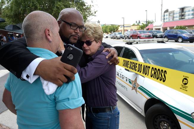 From left, Terry DeCarlo, executive director of the LGBT Center of Central Florida; Kelvin Cobaris, pastor of the Impact Church; and Orlando City Commissioner Patty Sheehan console each other Sunday, June 12, 2016, after a shooting at Pulse nightclub in Orlando, Fla. At least 50 people were killed and 53 injured.