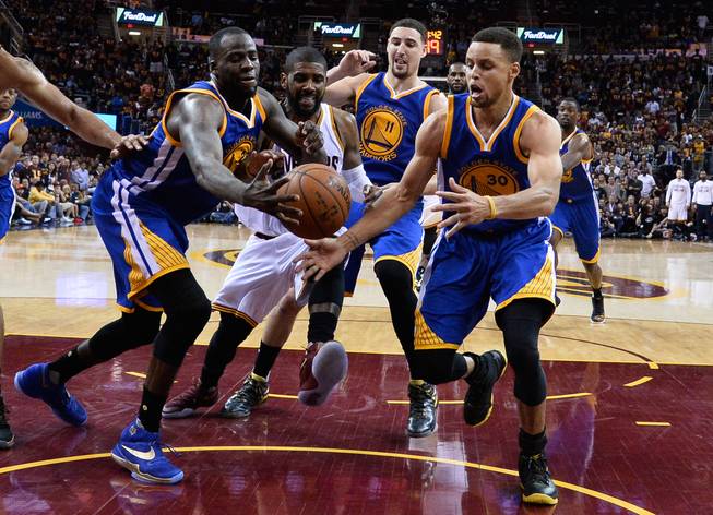 The Golden State Warriors’ Draymond Green, Cleveland Cavaliers’ Kyrie Irving and Warriors’ Klay Thompson and Stephen Curry pursue a loose ball Friday, June 10, 2016, during the second half of Game 4 in the NBA Finals in Cleveland. Golden State won 108-97.