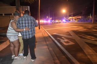 Bystanders wait down the street from a shooting involving multiple fatalities at the Pulse nightclub in Orlando, Fla., Sunday, June 12, 2016.