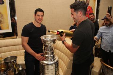 Sidney Crosby of the Stanley Cup champion Pittsburgh Penguins and former Penguin Pascal Dupuis enjoy Moet Imperial Gold in the Stanley Cup on Tuesday, June 21, 2016, at Fizz in Caesars Palace.