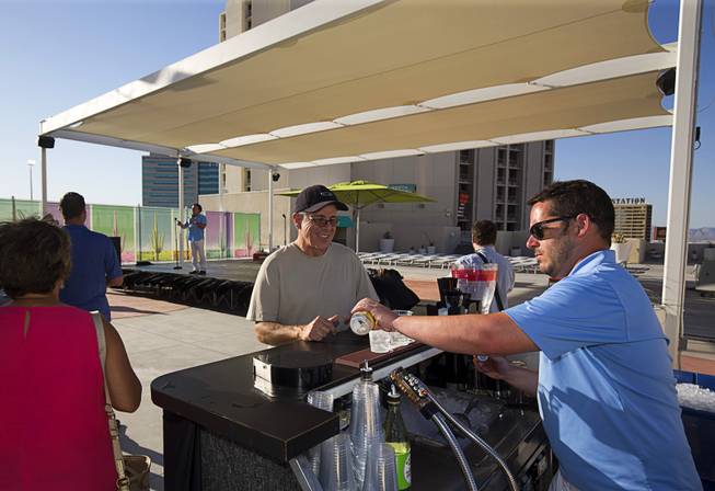 Bartender Justin Catamese prepares a drink for Russell McGarry during a preview event for the new rooftop pool at the Plaza in downtown Las Vegas Thursday, June 23, 2016. The pool officially opens on July 2.