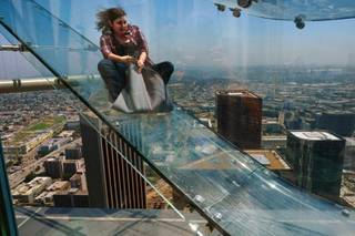 A member of the media rides down a glass slide during a media preview at the U.S. Bank Tower building in downtown Los Angeles on Thursday, June 23, 2016. Starting this weekend, thrill-seekers can begin taking the Skyslide, a 1,000 feet high slide, perched on the outside of the tallest skyscraper west of the Mississippi.