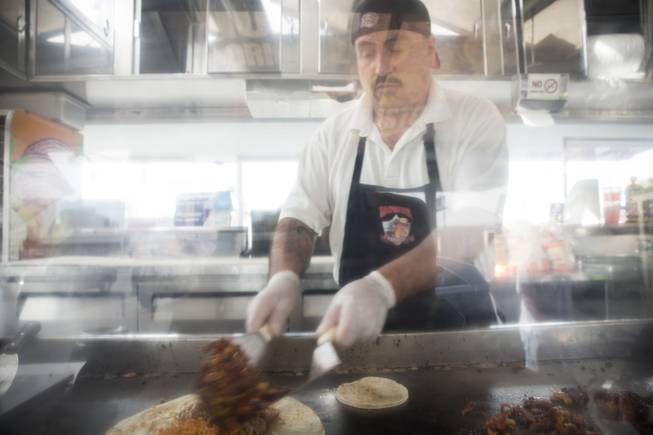 Chef Francisco Cruz at the Taqueria El Buen Pastor taco truck prepares a burrito on the grill, Monday, June 6, 2016.