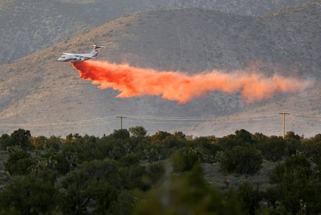 An air tanker drops retardant on a brush fire near Lovell Canyon Road and State Route 160 Sunday, June 26, 2016. 