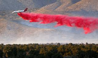An air tanker drops retardant on a brush fire near Lovell Canyon Road and State Route 160 Sunday, June 26, 2016.