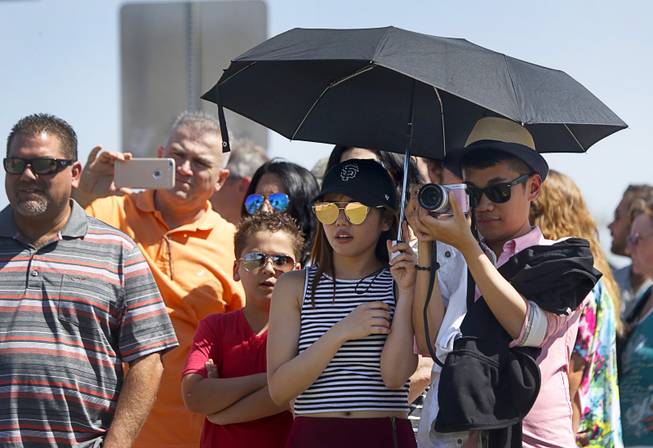 Erika Dorado of Los Angeles holds a shade umbrella for Chris Resma as they take photos at the "Welcome to Las Vegas" sign Sunday, June 26, 2016. The high temperature in Las Vegas Sunday was 109 degrees. 