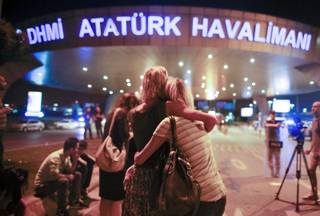 Passengers embrace each other at the entrance to Istanbul's Ataturk airport, early Wednesday, June 29, 2016 following their evacuation after a blast. Suspected Islamic State group extremists have hit the international terminal of Istanbul's Ataturk airport, killing dozens of people and wounding many others, Turkish officials said Tuesday. Turkish authorities have banned distribution of images relating to the Ataturk airport attack within Turkey. 